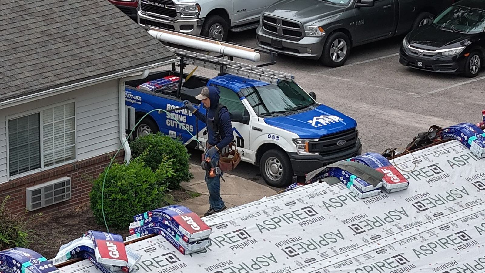 K&D Roofing truck parked at a home while the crew works on the roof