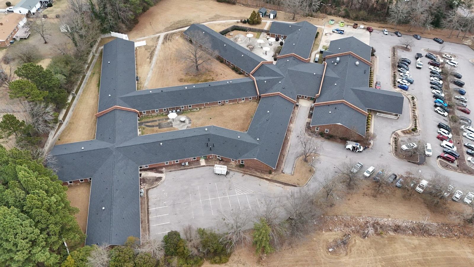 Drone view of a large commercial building complex with a new shingle roof