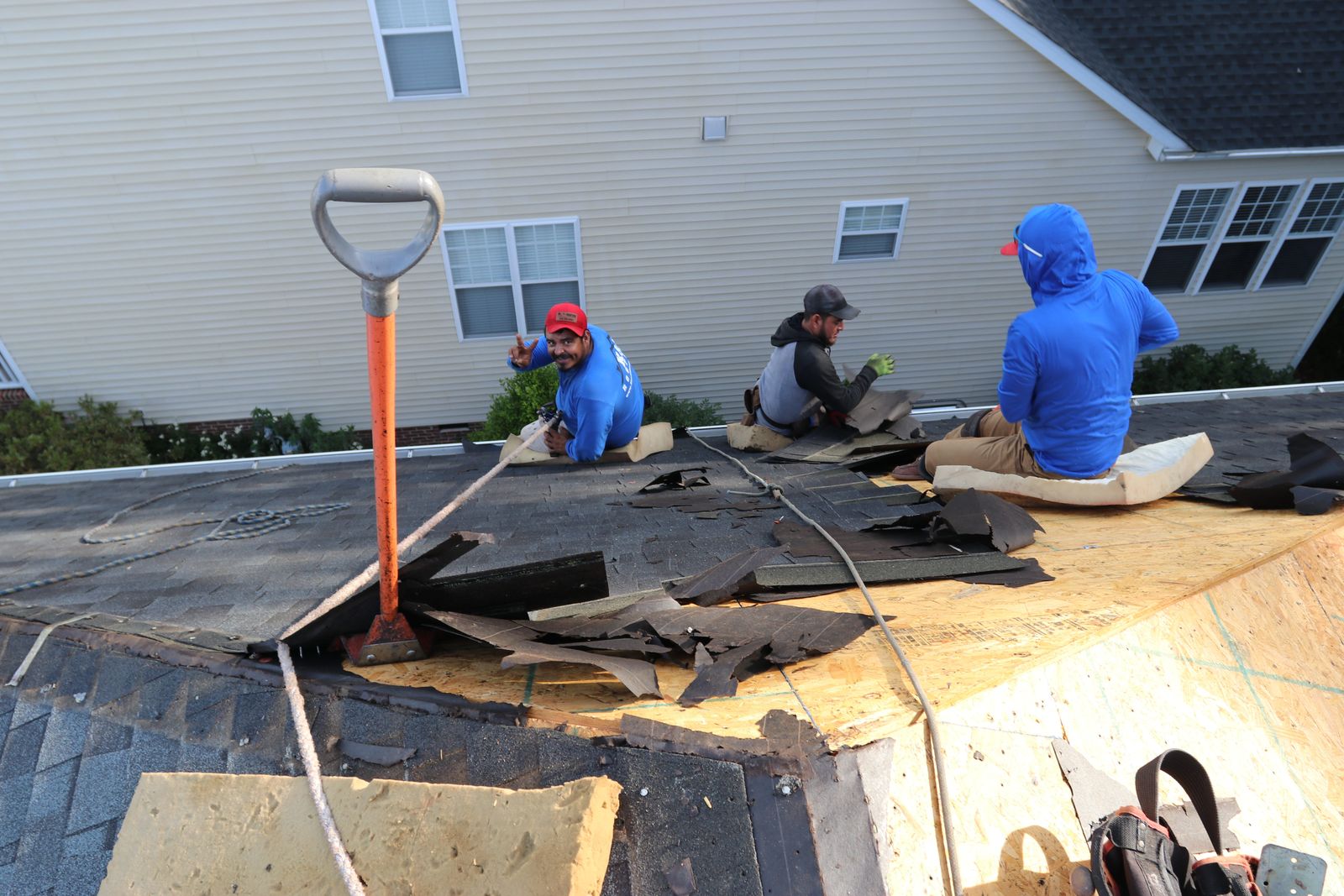 K&D Roofing crew tearing off old shingles down to the roof decking