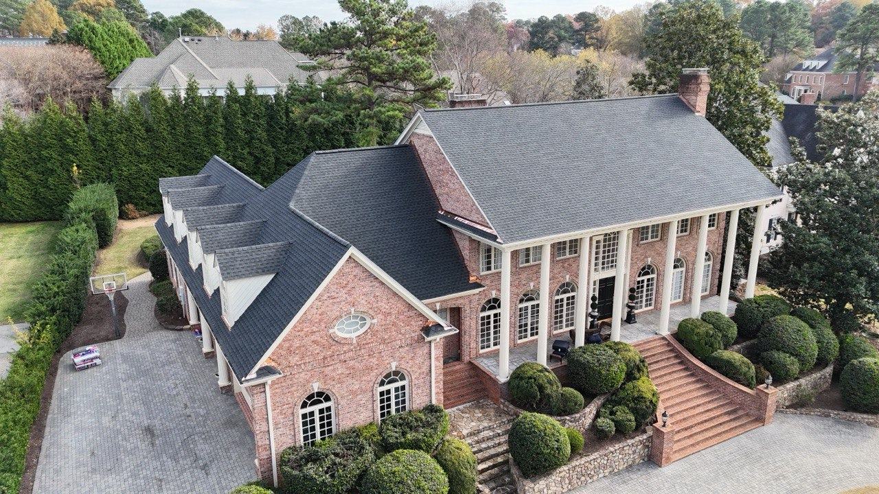 Brick colonial home with a gray shingle roof