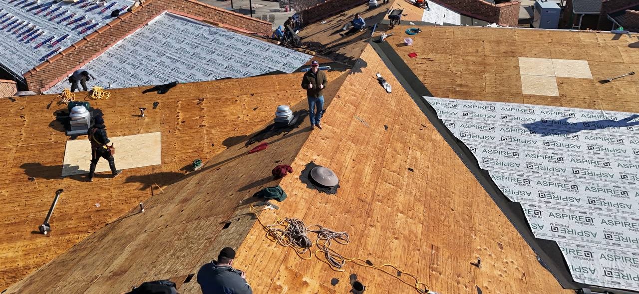 Aerial view of a roofing crew working on synthetic underlayment