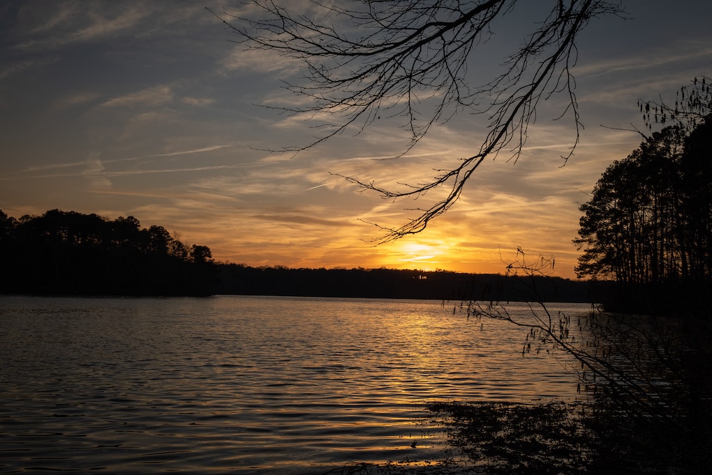 View of the golden horizon during sunset at over the water at Lake Benson Park in Garner, North Carolina.