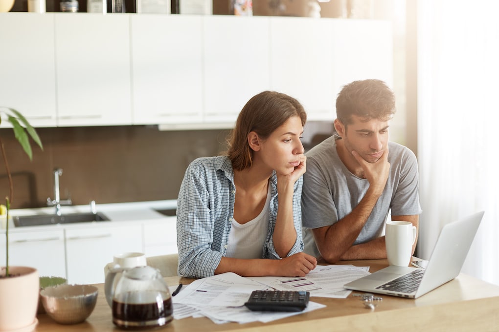 couple looking attentively into roof warranties and insurance claim
