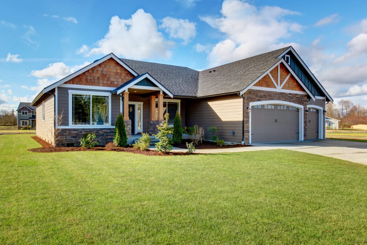 Large modern house with walkway and lots of grass. roof warranty