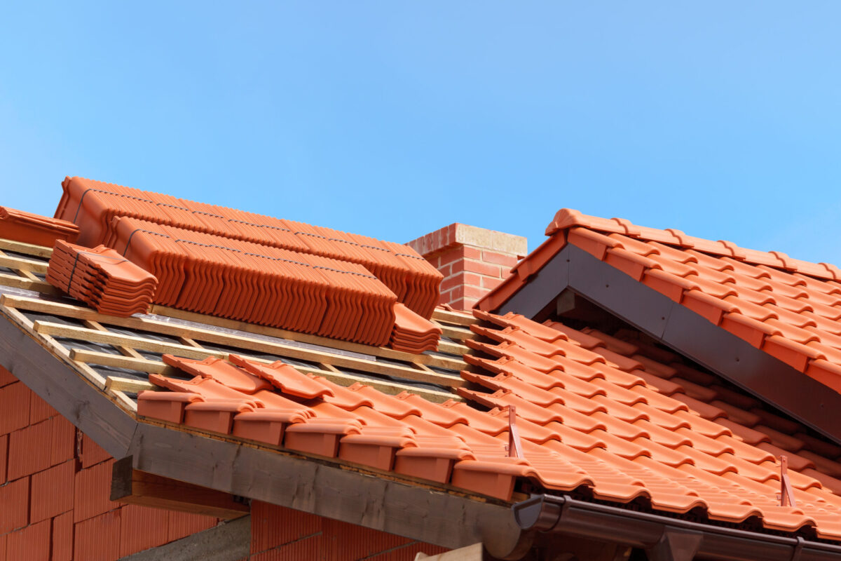 tile roof replacementroof under construction with stacks of red ceramic roof tiles ready to fasten