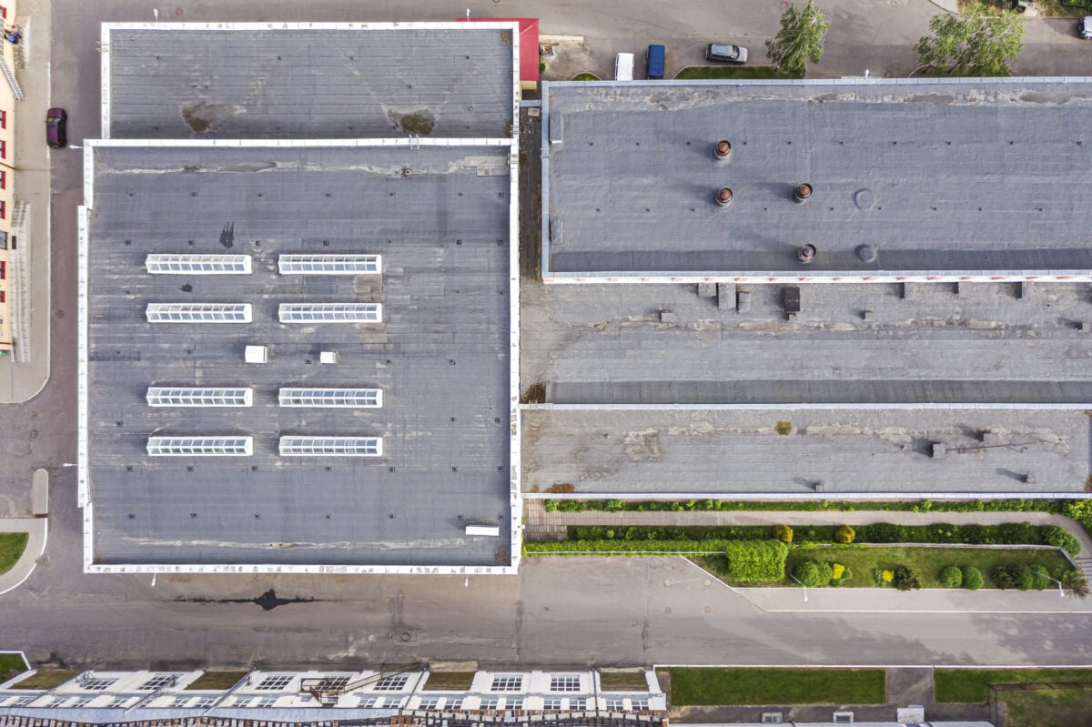 shingles roof of the industrial building with skylights. aerial top view.